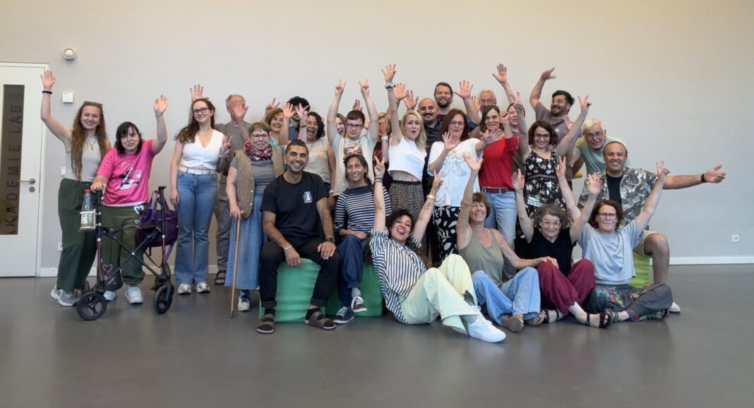 Das Ensemble des Theaterlabors Nürnberg mit erhobenen Armen im Probenraum